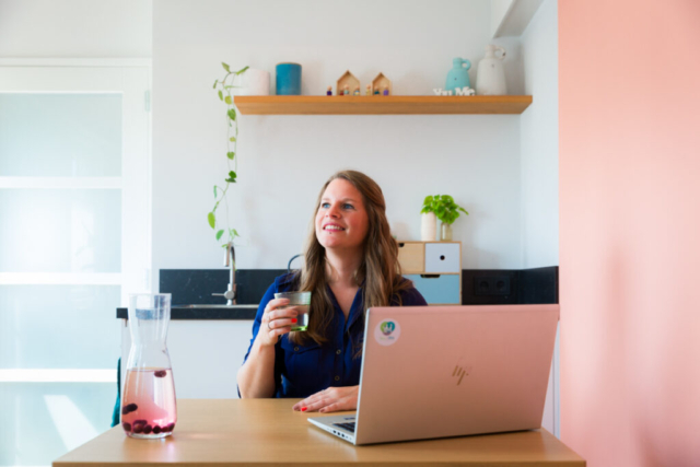 Mirjam van You & Me psychologie kijkt dromerig naar buiten zittend achter haar laptop